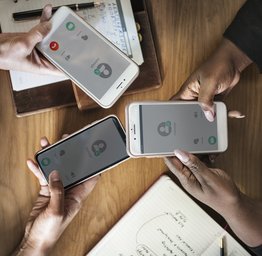 three people with phones in their hands